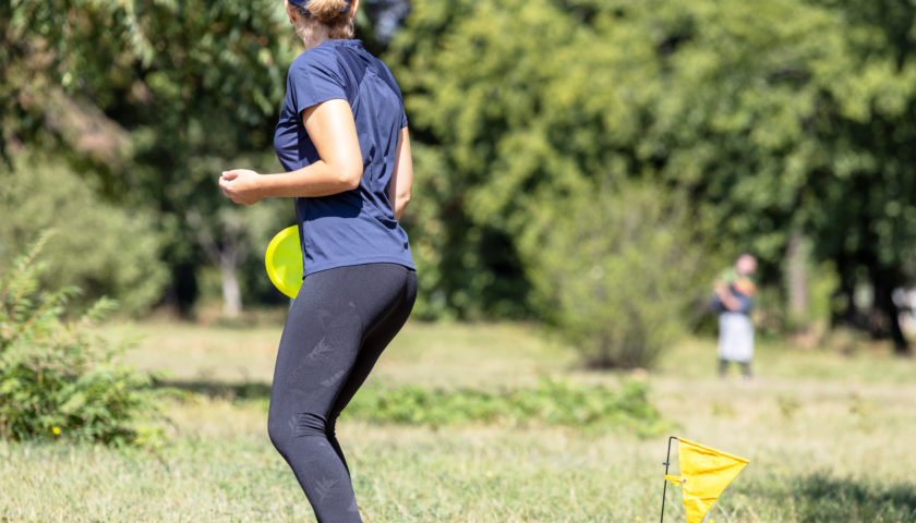 Frau beim discgolfen